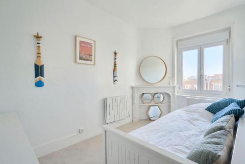 a white bedroom with a bed and a window at Superbe appartement, balcon vue mer, 3 chambres! in Bray-Dunes