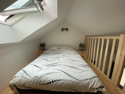 ein kleines Schlafzimmer mit einem Bett im Dachgeschoss in der Unterkunft Chez Mongery in Landreville