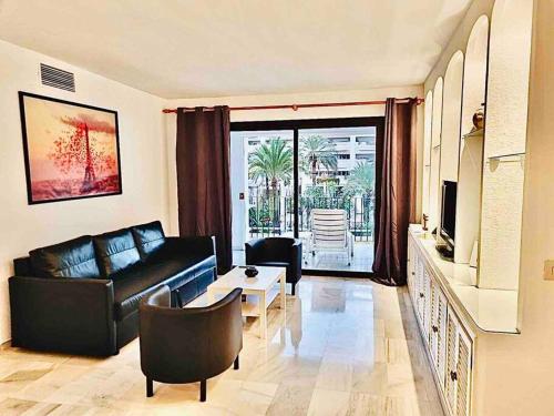 sala de estar con sofá y mesa en PUERTO BANUS, 2 ROOMS, POOL AND PRIVATE PARKING., en Marbella