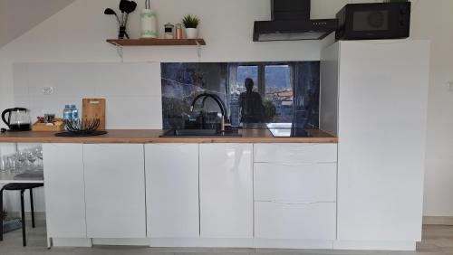 a kitchen with white cabinets and a sink at Apartamenty Bujaki Ustroń in Ustroń