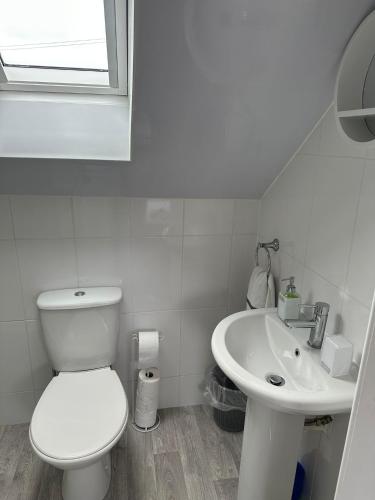 a white bathroom with a toilet and a sink at 30 College Street, Buckhaven, Leven, Fife, KY81JX in Buckhaven