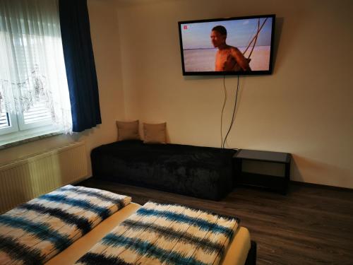 uma sala de estar com um sofá e uma televisão na parede em Panoramablick Exklusiv em Villach