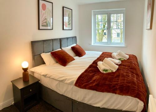 a bedroom with a large bed with towels on it at The Comfy Flat- Modern & Bright 2 Bedrooms Apartment in Liverpool