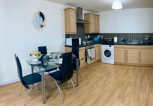 uma cozinha com uma mesa e cadeiras numa cozinha em The Comfy Flat- Modern & Bright 2 Bedrooms Apartment em Liverpool