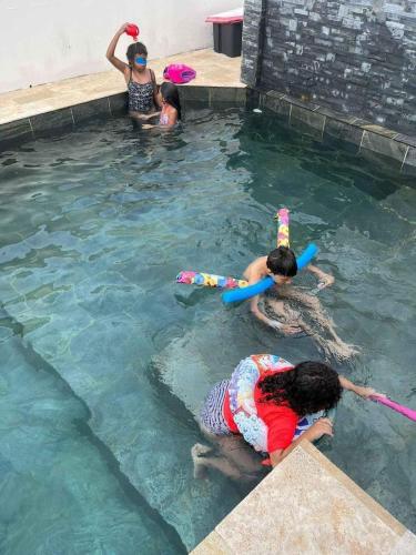 a group of children playing in a swimming pool at Villa Mary Guest House in Saint-André