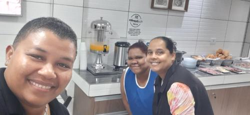 three people posing for a picture in a kitchen at Motel Softy (Adults Only) in Osasco