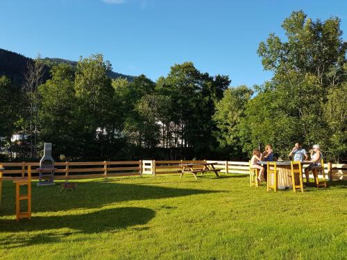 a group of people sitting at tables in the grass at appart l'Écureuil 4 étoiles in Cornimont