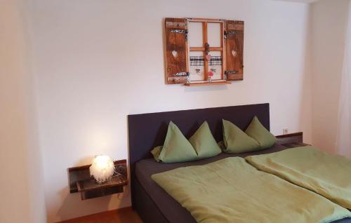 1 dormitorio con cama con almohadas verdes y espejo en Bergjuwel Kleinwalsertal, en Hirschegg