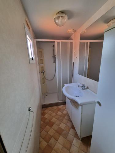 a white bathroom with a sink and a shower at Mobile Home Emma in Lido di Dante