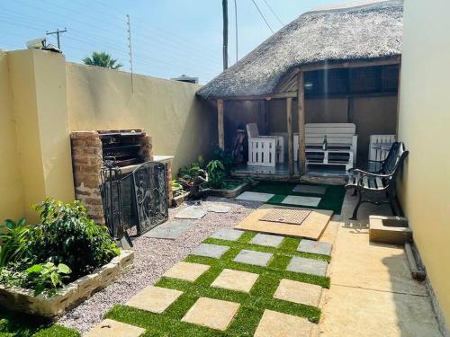 une petite cour avec une maison dotée d'une terrasse dans l'établissement modern, two-story luxury house, à Gaborone