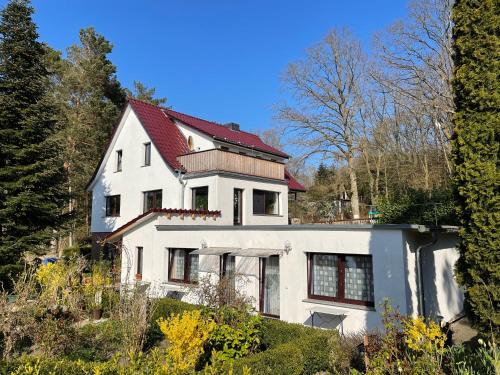 Casa blanca con techo rojo en Ferienwohnungen Schramm & Rolinski en Lietzow