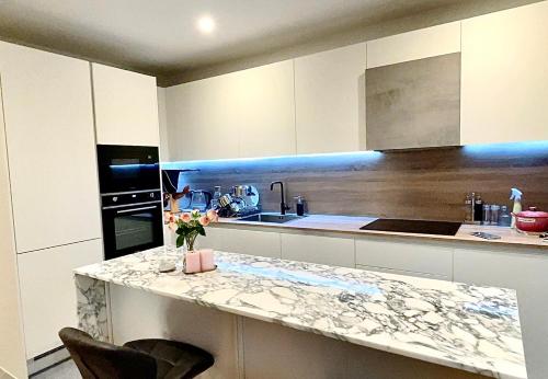 a white kitchen with a counter and a counter top at Stunning property with London city and river views in London