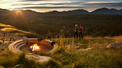 two people standing next to a fire pit in a field at Suncadia Lodge Studio Unit in Cle Elum