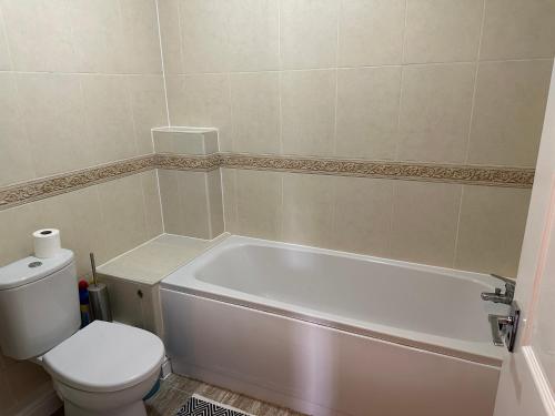 a bathroom with a white tub and a toilet at Shepherds View, Flat 8 in Derby