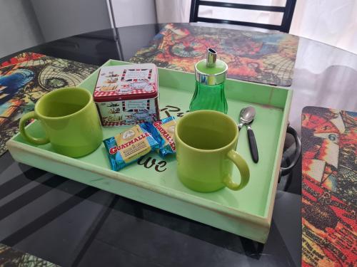 una bandeja con dos tazas y una botella en una mesa en Casa a minutos del Aeropuerto en Ezeiza