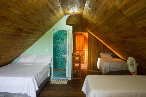 a attic bedroom with two beds and a mirror at Hotel Calamari Baru in Playa Blanca