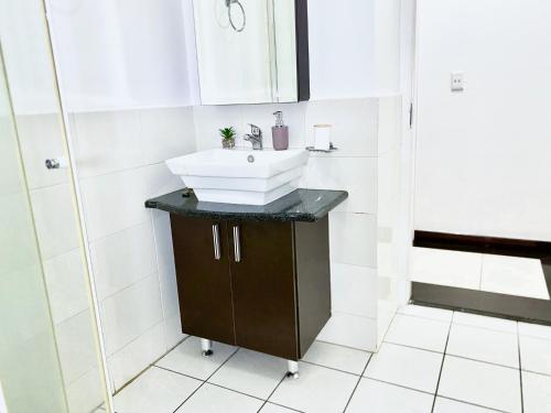 a bathroom with a sink and a shower at Midrand Siena Sun Luxury Suites 3 with water reserve in Midrand