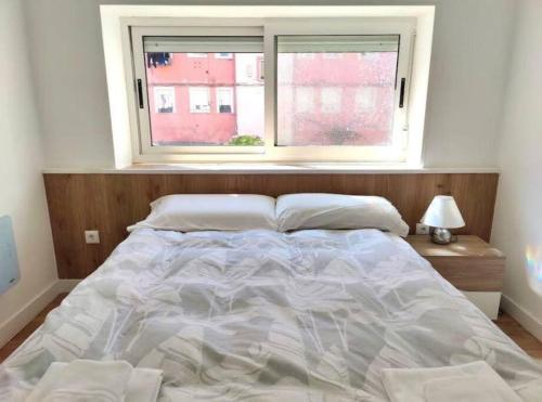 - un grand lit dans une chambre avec fenêtre dans l'établissement Apartamento Casa Davila, à Santander