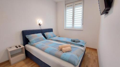una piccola camera con letto blu e finestra di Tirkiz a Sremska Kamenica