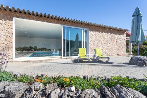 two chairs and an umbrella in front of a building at Casa Monteiro - Piscina Interior Aquecida in Santarém