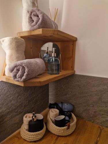ein Holzregal mit Handtüchern und Tassen darauf in der Unterkunft klein&fein in Neustift im Stubaital