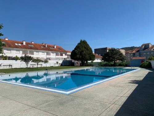 a large blue swimming pool in a courtyard at URBANIZACION CON PISCINA ARNELAS SANXENXO in Sanxenxo