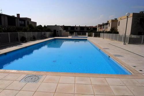 duży niebieski basen w budynku w obiekcie A 8 mn A PIED DES PLAGES APPARTEMENT AVEC PISCINE ET TENNIS w Argelès-sur-Mer