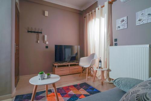 ein Wohnzimmer mit einem Sofa, einem TV und einem Tisch in der Unterkunft Joye Haste in Edessa