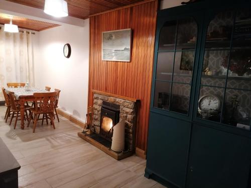 uma sala de jantar com uma mesa e uma lareira em Ferguson's Traditional Townhouse em Dunkineely