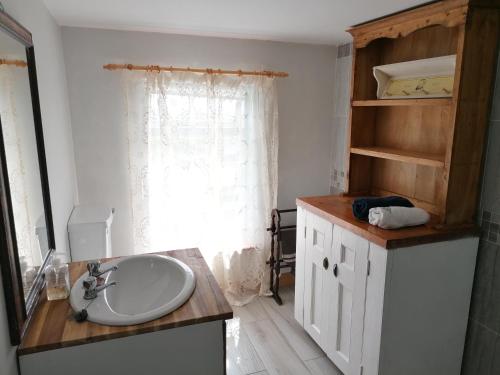 baño con lavabo y ventana en Ferguson's Traditional Townhouse, en Dunkineely