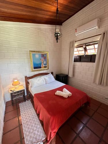 a bedroom with a bed with a red blanket at Itacimirim Beach House in Itacimirim