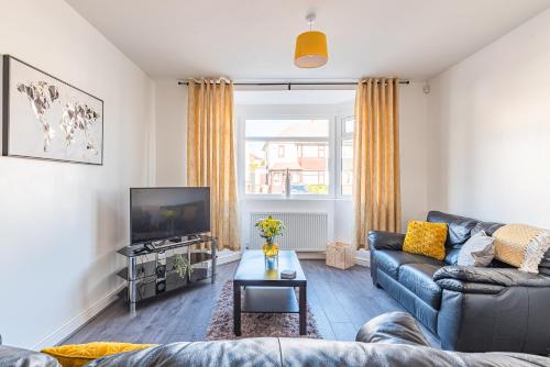 a living room with a couch and a tv at Beautiful 3 bedroom House near West Bromwich -contractors, Family, NHS in Swan Village