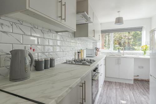 a kitchen with white cabinets and a counter top at Beautiful 3 bedroom House near West Bromwich -contractors, Family, NHS in Swan Village