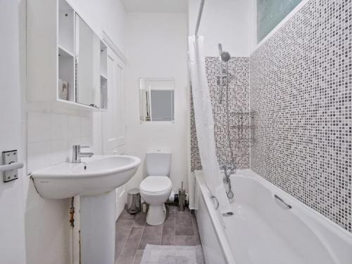 a white bathroom with a sink and a toilet at Entire townhouse in central Derby - with Garden! in Derby