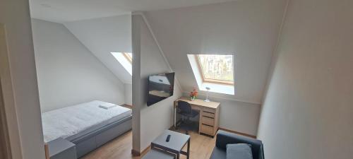 1 dormitorio con cama, escritorio y espejo en KL Apartments, en Leipzig