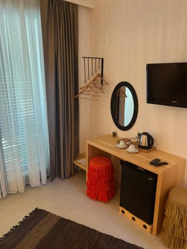 a room with a mirror and a table with a stool at LAGOM HOTEL in Seferihisar