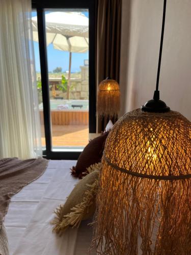 a bedroom with a lamp on a bed with a window at LAGOM HOTEL in Seferihisar