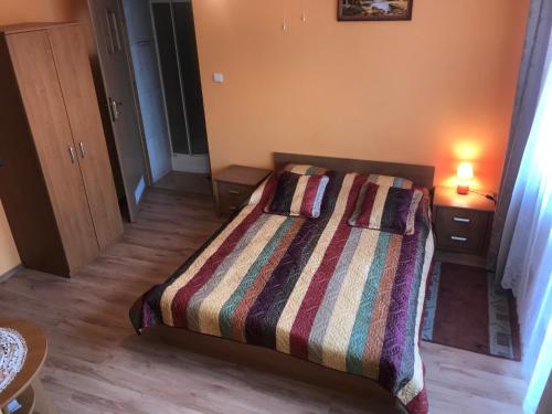 um quarto com uma cama com um edredão listrado em Holica em Krynica-Zdrój