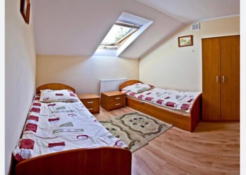 a bedroom with two beds and a skylight at Holica in Krynica Zdrój