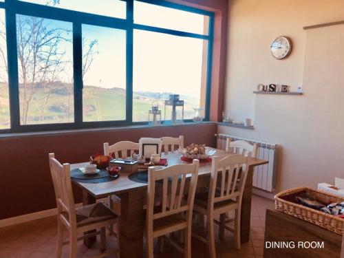 a dining room with a table and chairs and a window at Villetta rosso Rubino in Vignale Monferrato