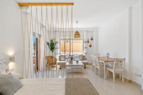 a living room and dining room with a bed and a table at Niña Sureña Home Añoreta Golf in Torre de Benagalbón