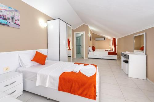 a white bedroom with a large bed and a bathroom at Yaşam Park Rena Villaları Ölüdeniz in Fethiye
