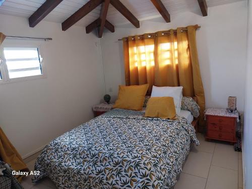 Anse-Bertrand的住宿－Haut de villa agréable et paisible climatise, wifi，一间卧室配有一张带木制床头板的床