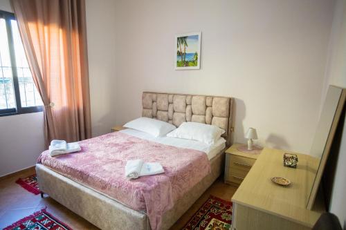 Schlafzimmer mit einem Bett, einem Tisch und einem Fenster in der Unterkunft Vila AULONA in Vlorë