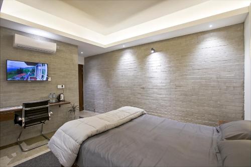 a bedroom with a bed and a brick wall at Rahma’s B&B in Sylhet