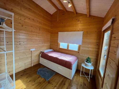 ein Schlafzimmer mit einem Bett in einer Holzhütte in der Unterkunft La cabaña de Quino in Antigua