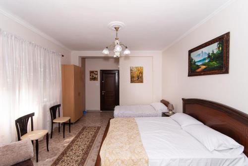 een slaapkamer met een bed, een tafel en stoelen bij ERLA'S apartment in Tirana