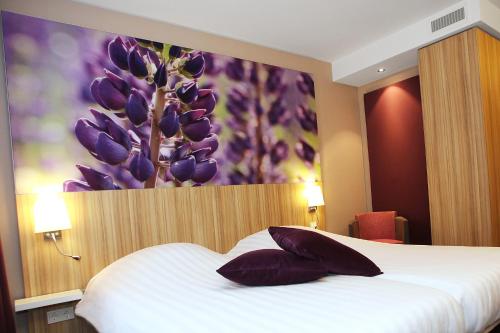 a bedroom with a bed with purple flowers on the wall at Hotel Ernst Sillem Hoeve in Den Dolder