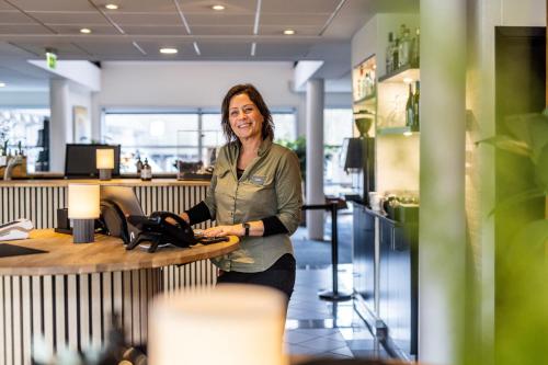 a woman standing at a counter in an office at The Lodge Billund in Billund