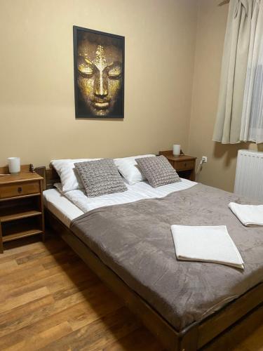 1 dormitorio con 1 cama grande con máscara en la pared en 4 You Mini Apartman Egerszalók, en Egerszalók
